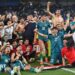 The Iraq squad celebrate on the pitch after sealing World Cup qualification